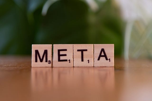 Four wooden Scrabble tiles lined up on a table spell the word 